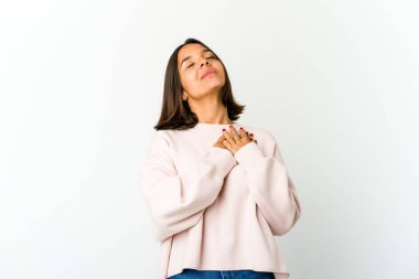 Genç melez kadının dost canlısı bir ifadesi var, avuçlarını göğsüne bastırıyor. Aşk konsepti.