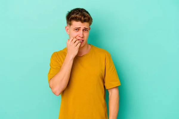 Young Caucasian Man Isolated Blue Background Biting Fingernails Nervous Very — Stock Photo, Image