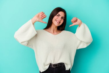 Mavi arka planda izole genç beyaz kadın gururlu ve kendinden emin hissediyor, örnek olarak..