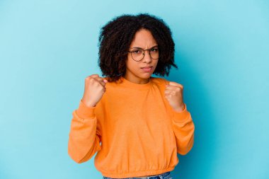 Genç Afro-Amerikan melez kadın izole edilmiş kameraya yumruk gösteriyor, agresif yüz ifadesi var..