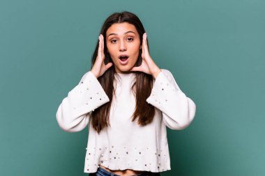 Mavi arka planda yalnız yaşayan genç Hintli kadın şaşırdı ve şok oldu..