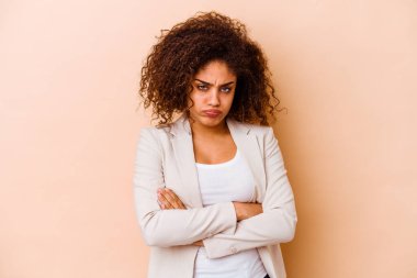 Bej arka planda izole edilmiş genç Afrikalı Amerikalı kadın yanaklarına üflüyor, yorgun bir ifade takınıyor. Yüz ifadesi kavramı.