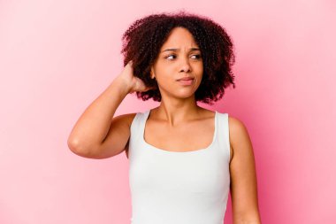 Genç Afro-Amerikan melez kadın kafasının arkasına dokunuyor, düşünüyor ve bir seçim yapıyor..