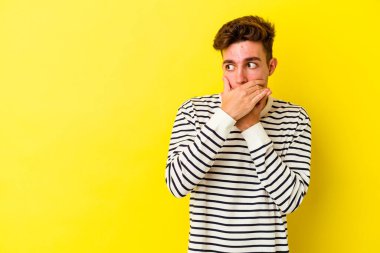 Renkli arka planda poz veren beyaz bir genç. 