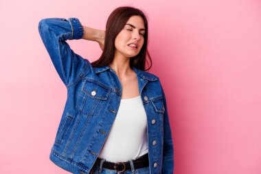 Genç, beyaz bir kadın pembe arka planda izole edilmiş. Durağan yaşam tarzından dolayı boyun ağrısı çekiyor..