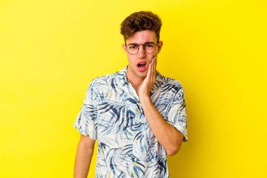 Sarı arka planda izole genç beyaz adam güçlü bir diş ağrısı, azıdişi ağrısı var..