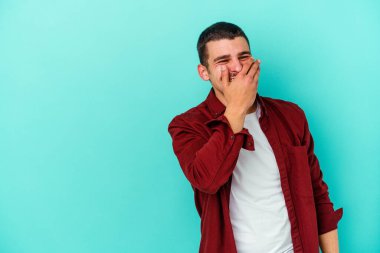 Kafkasyalı genç adam mavi arka planda yalnızdı gülerek, kaygısızca, doğal duygularla.