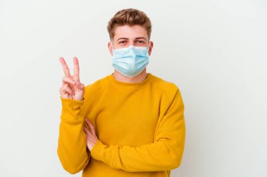 Koronavirüs maskesi takan genç adam beyaz arka planda iki numarayı parmaklarıyla gösteriyor..