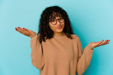 Genç Afrikalı Afro-Amerikan kadın şüpheci davranıp omuz silkiyor..