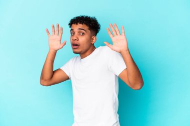 Genç Afro-Amerikan kıvırcık adamı mavi üzerine izole edildi.
