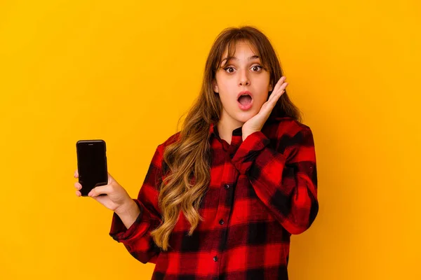 Junge Kaukasische Frau Mit Handy Isoliert Auf Gelbem Hintergrund Überrascht — Stockfoto