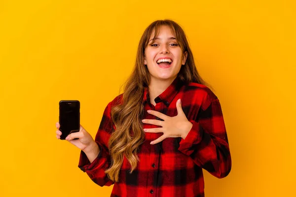 Junge Kaukasische Frau Mit Handy Isoliert Auf Gelbem Hintergrund Lacht — Stockfoto