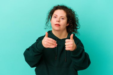 Down sendromlu kadın kendini soyutlamış. Baş parmağını kaldırıyor, gülümsüyor ve kendinden emin..