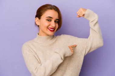 Genç Arap melez kadın güçlü hareketini kollarıyla gösteriyor, kadınsı gücün sembolü.