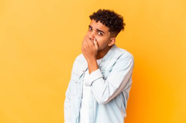 Genç Afro-Amerikalı kıvırcık adam, mor ağızla izole edilmiş, elleri endişeli görünüyor..