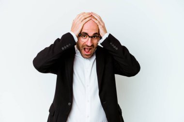 Genç, beyaz, kel bir adam mavi arka planda izole edilmiş bağırıyor, çok heyecanlı, tutkulu, bir şeyden memnun..