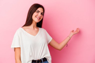 Pembe arka planda soyutlanmış beyaz bir kadın hoş bir yüz ifadesi sergiliyor..