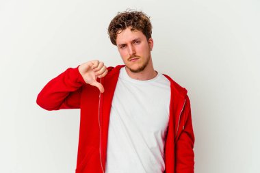 Beyaz arka planda izole edilmiş genç beyaz adam baş parmağını aşağı gösteriyor, hayal kırıklığı konsepti..