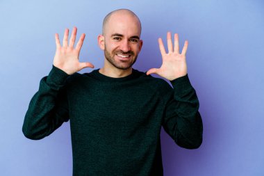 Mor arka planda izole edilmiş beyaz kel bir adam 10 numarayı elleriyle gösteriyor..