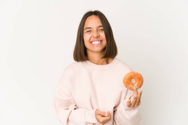 Genç İspanyol kadın donut yiyor, gülüyor ve eğleniyor..