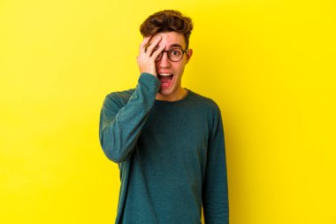 Renkli arka planda poz veren beyaz bir genç. 