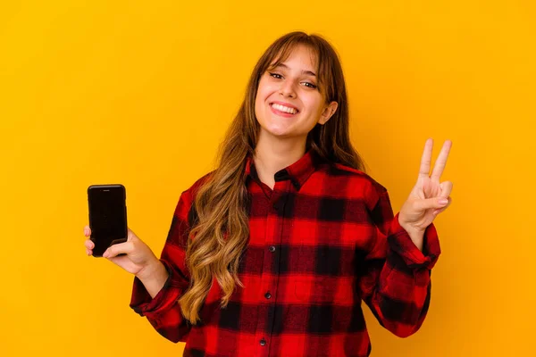 Junge Kaukasische Frau Hält Handy Isoliert Auf Gelbem Hintergrund Und — Stockfoto