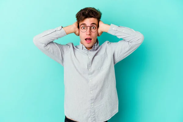 Joven Hombre Caucásico Aislado Sobre Fondo Azul Cubriendo Las Orejas — Foto de Stock