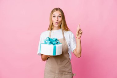 Genç Rus fırıncı kadın elinde lezzetli bir pasta tutuyor. Harika bir fikri var, yaratıcılık kavramı..