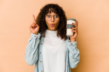 Afro-Amerikan Afro-Amerikan kadın elinde kahve ile harika bir fikir üretiyor..