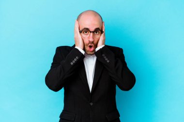 Mavi arka planda izole genç beyaz adam şok oldu, o önemli bir toplantı hatırladı.