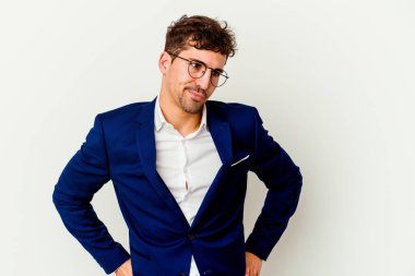 Beyaz arka planda soyutlanmış, kafası karışmış, şüpheci ve kararsız genç beyaz bir adam..