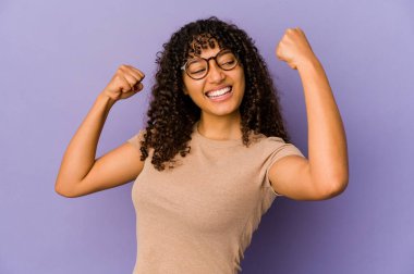 Genç Afro-Amerikan Afro kadın zafer kazandıktan sonra yumruğunu kaldırdı..