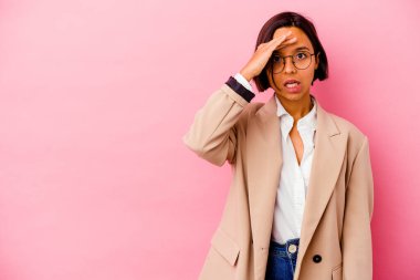 Pembe arka planda izole edilmiş genç iş kadını yüksek sesle bağırıyor, gözleri açık ve elleri gergin tutuyor..