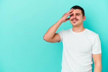 Kafkasyalı genç adam mavi arka planda yalnızdı gülerek, kaygısızca, doğal duygularla.