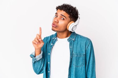 Genç Afro-Amerikan kıvırcık adamı kulaklıkla müzik dinleyip yaratıcılık kavramını benimsiyor..