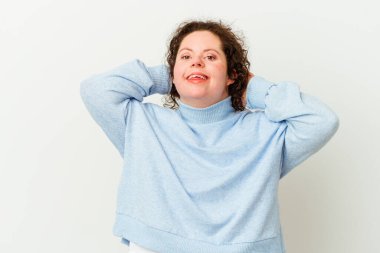 Down sendromlu bir kadın yalnız, kendinden emin, elleri başının arkasında..