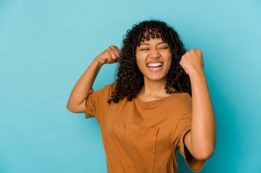 Genç Afro-Amerikan Afro kadın zafer kazandıktan sonra yumruğunu kaldırdı..