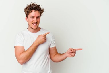 Beyaz arka planda izole edilmiş genç beyaz bir adam işaret parmağıyla fotokopi alanını işaret ederek heyecan ve arzusunu ifade ediyor..