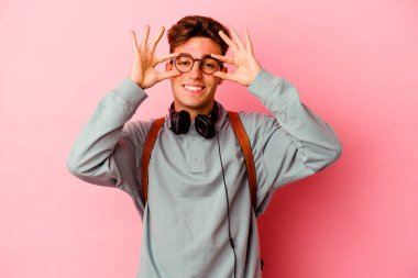 Pembe arka planda izole edilmiş genç bir öğrenci gözlerinde işaret var.