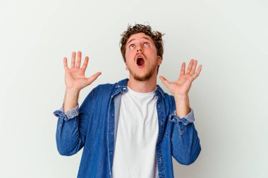 Beyaz arka planda izole edilmiş genç beyaz adam gökyüzüne haykırıyor, yukarı bakıyor, hayal kırıklığına uğramış..