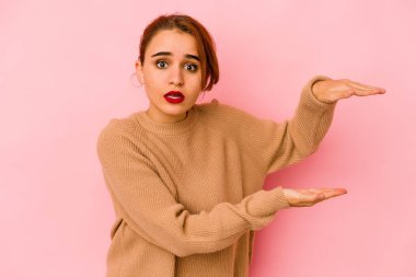 Genç Arap melez kadın şok oldu ve hayret içinde elleri arasında bir kopya alanı tutuyor..