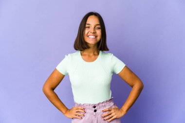 Genç melez kadın kendine güveniyor, ellerini kalçasında tutuyor..