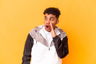 Genç Afro-Amerikalı kıvırcık adam mor üzerine izole edilmiş gizli bir sıcak fren haberi veriyor ve yan bakıyor.