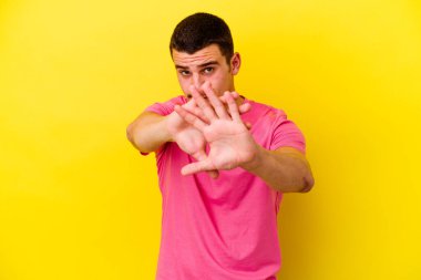 Sarı arka planda izole edilmiş beyaz bir adam inkar jesti yapıyor.