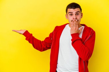 Sarı arka planda izole edilmiş beyaz bir adam, avuç içinin fotokopi alanını tutmaktan etkilenmiş..