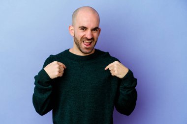 Mor arka planda izole edilmiş beyaz saçlı genç adam parmağını göstererek şaşırdı, geniş bir gülümsemeyle..