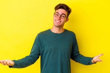 Sarı arka planda izole edilmiş beyaz bir genç hoş bir yüz ifadesi sergiliyor..