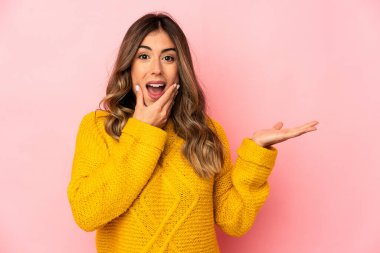 Kafkasyalı genç bir kadın, avucunun içinde fotokopi alanı tutuyor, el üstünde tutuyor. Şaşırmış ve mutlu..