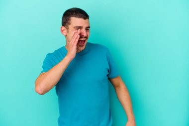 Mavi arka planda izole edilmiş beyaz bir adam heyecanlı bir şekilde bağırıyor..