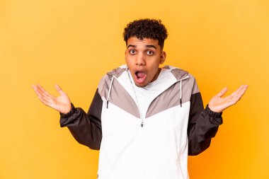 Genç Afro-Amerikalı kıvırcık adam Mor renkte izole edilmiş şaşırmış ve şok olmuş.